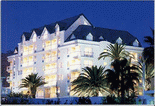 A large white building with palm trees in front of it.